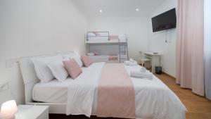 a bedroom with a large white bed with pink pillows at Lovely Rooms by Rentbeat in Civitavecchia +189 photos