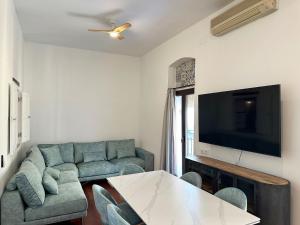 a living room with a couch and a tv at La Alcazaba de Triana in Seville