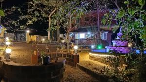 a house lit up at night with lights at Nature Inn Cottages in Gokarna