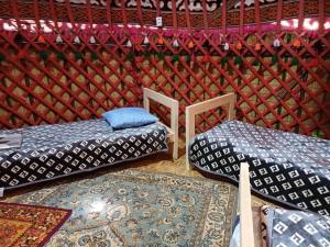 a room with two beds and a rug in a room at Sayakat Eco Camp in Kaji-Say
