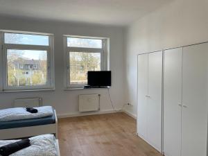 a bedroom with a bed and a tv in it at Lichtdurchflutete 3-Zimmer-Wohnung in Brühl