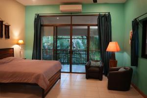 a bedroom with a bed and a chair and a window at home stay pool villa chiang mai in Ban Thung Satong +25 photos