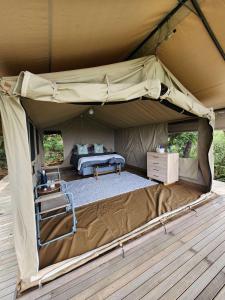 a tent with a bed and a table in it at Loziba Wildlife Reserve Tented Camp in Vryheid