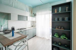 - une cuisine avec une table, des chaises et un comptoir dans l'établissement Homiday - Appartamenti I Gabbiani, à Pineto