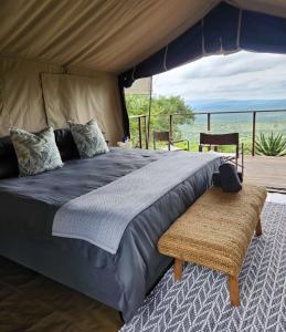 a bedroom with a bed and a view of the ocean at Loziba Wildlife Reserve Tented Camp in Vryheid