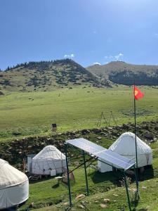 a group of tents in a field with a flag at Sayakat Eco Camp in Kaji-Say
