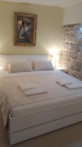 a bedroom with a large bed with a painting on the wall at Rooms Valentino in Split
