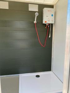 纽波特Usk View Glamping Caerleon的墙上装有红色软管的淋浴