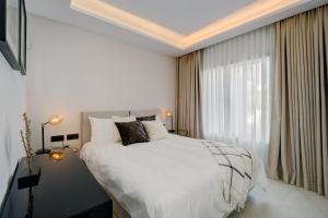 Un dormitorio con una gran cama blanca y una ventana. en The Next Gen Villa, en Estepona 33 fotos más