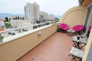 a balcony with pink chairs and a table on a balcony at Apartment Gold Plus in Split