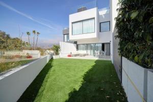 una gran casa blanca con un patio de hierba en The Next Gen Villa, en Estepona