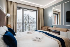 a bedroom with a large bed with a large window at Hotel Pulaski Residence in Ełk