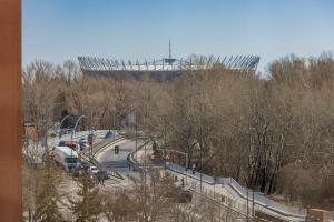 a parking lot with cars parked in front of a stadium at Bright CityView Apartment with AC near PGE Narodowy by Noclegi Renters in Warsaw