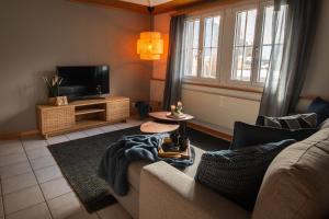 un soggiorno con un divano e una TV di Beachhouse 16 Brienzersee a Brienz
