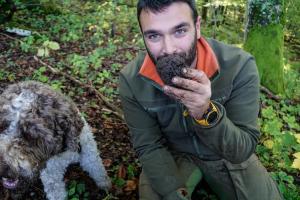 a man with a beard sitting next to a dog at 1st Truffle House Žumberak 