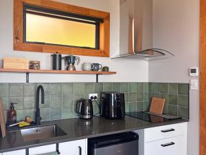 a kitchen with a sink and a counter top at Pahautane Ridge - Elevated Sea Views Outdoor Stone Bath in Punakaiki