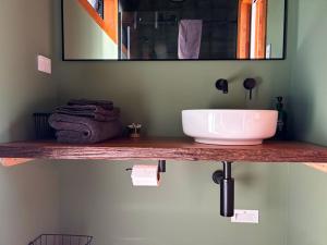 a bathroom with a sink and a mirror at Pahautane Ridge - Elevated Sea Views Outdoor Stone Bath in Punakaiki