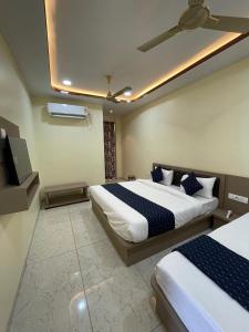 Un dormitorio con dos camas y un televisor de pantalla plana. en Hotel Mb Nirala Shyam, en Khātu