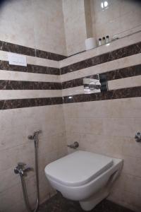 a bathroom with a white toilet and a shower at Hotel R S RESIDENCY in Varanasi +21 photos