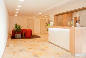 an office lobby with a counter and a table and chairs at Hotel Jägerhaus in Esslingen in Esslingen