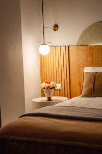 Un dormitorio con una cama y un jarrón de flores. en Hane Cunda, en Ayvalık