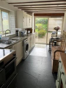 a kitchen with a sink and a dishwasher in it at Bayvil - Nevern in Velindre-farchog