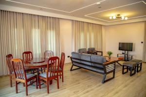 a dining room with a table and chairs and a couch at Rebero A3s apartment in Kigali