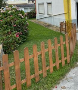 a wooden fence in front of a yard at A casa da Sia in Ribadeo