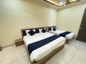 Un dormitorio con dos camas con almohadas azules y blancas. en Hotel Mb Nirala Shyam, en Khātu 11 fotos más