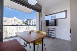 a dining room with a table and a large window at Urban Nest Yaavetz Tlv in Tel Aviv