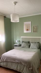 a bedroom with a large bed with green walls at A casa da Sia in Ribadeo