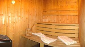 uma sauna de madeira com uma garrafa e um copo em Almhüttendorf Klippitztörl em Klippitztorl