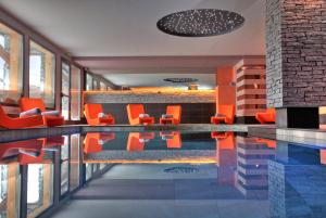 a swimming pool in a house with orange chairs at Residence Montana Plein Sud in Val Thorens