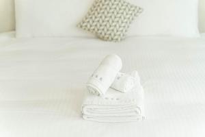 un mucchio di asciugamani e un rotolo di carta igienica su un letto di 眺浪島民宿 a Fan-shu-liao Altre 37 foto