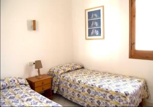 a room with two beds and a table with a lamp at Angelinas Villas 2 Hab con Piscina in Cala Blanca