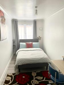a bedroom with a large bed and a window at The Grand Forsyth Apartment - Two bedroom in Dagenham