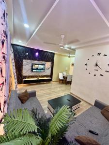 a living room with couches and a clock on the wall at Villa du bonheur in Ouagadougou
