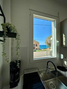 uma cozinha com uma janela com vista para o oceano em Breezy Sea View Appartment em Chania