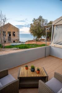 uma varanda com mesa e cadeiras e o oceano em Breezy Sea View Appartment em Chania
