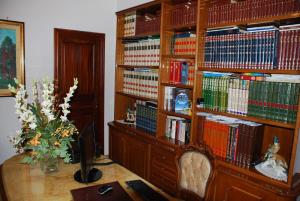 um quarto com uma secretária e uma prateleira cheia de livros em B&B La Rosa Antica em Castro di Lecce