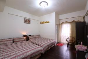 a bedroom with a bed and a chair and a window at Fangyi Homestay in Ji'an