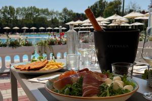 a table with two plates of food and a salad at San Benedetto Camping Relais in Peschiera del Garda