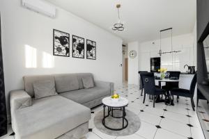 a living room with a couch and a table at Luxury Apartment 23 basen i sauna D&D Apartments in Dziwnów