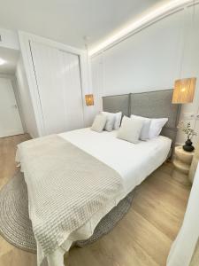 une chambre avec un grand lit blanc avec des oreillers blancs dans l'établissement Casa Levante Calpe - Beachfront, 2 pools, sea view, à Calp