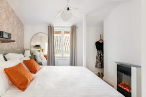 a bedroom with a white bed and a fireplace at Weekn'spa Tournus in Tournus +8 photos