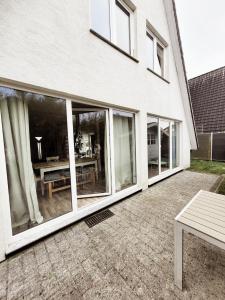 a patio with sliding glass doors in front of a house at Ferienhaus Rosa in Dorum Neufeld +22 photos