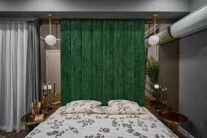 a bedroom with a green wall and a bed at Cozy Glow Loft in Bucharest