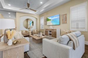 a living room with a couch and a tv at Curious Tides Gulf-Front 10BR Estate- Private Pools, Spas, Views townhouse in Fort Myers Beach