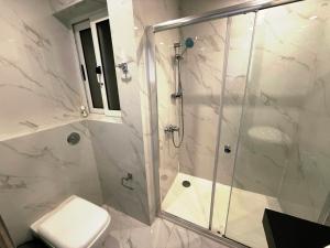 a bathroom with a shower and a toilet at The Urban Suites in Il-Gżira +139 photos
