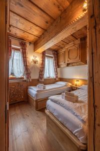 two beds in a room with wooden ceilings at Casa Col, vicina alle piste da sci e con vista Dolomiti in Cortina dʼAmpezzo